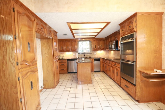 kitchen with a center island, stainless steel appliances, sink, decorative backsplash, and light tile patterned flooring