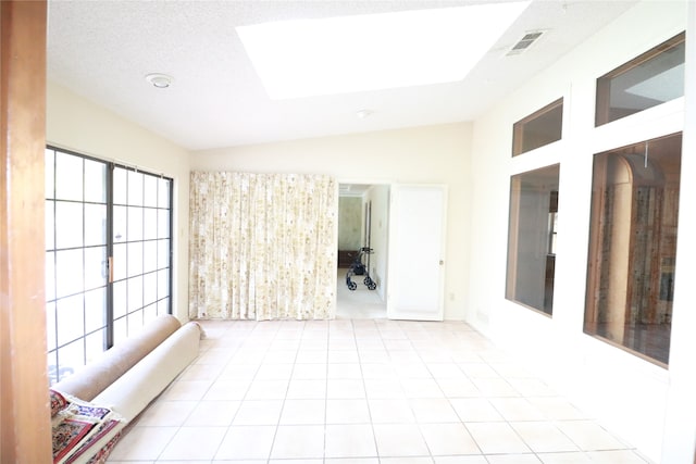 tiled empty room with lofted ceiling and french doors