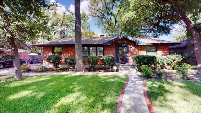 single story home featuring brick siding and a front lawn