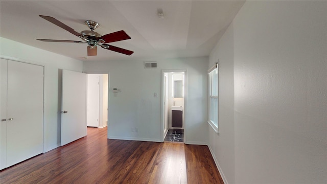 unfurnished bedroom with ceiling fan, wood-type flooring, a closet, and ensuite bath