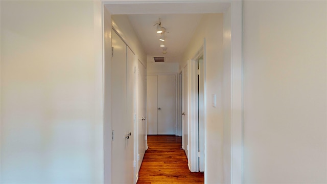 corridor featuring track lighting and wood-type flooring