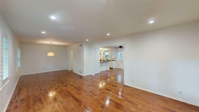 spare room featuring ceiling fan, plenty of natural light, and hardwood / wood-style floors