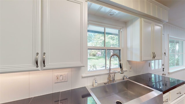 kitchen with white cabinetry, sink, and decorative backsplash