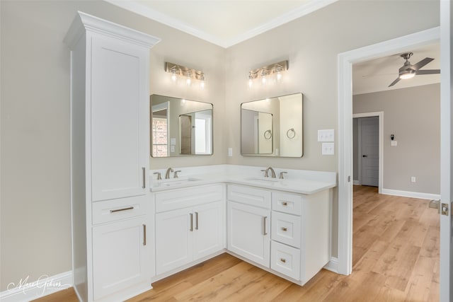 bathroom with ceiling fan, dual vanity, crown molding, and wood-type flooring