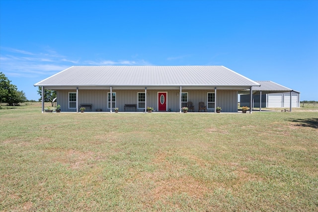 back of property with a yard, a garage, and covered porch