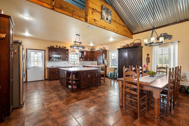 kitchen with hanging light fixtures, a healthy amount of sunlight, a center island, and appliances with stainless steel finishes