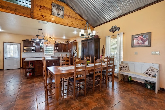 dining room featuring sink, a chandelier, high vaulted ceiling, and a healthy amount of sunlight