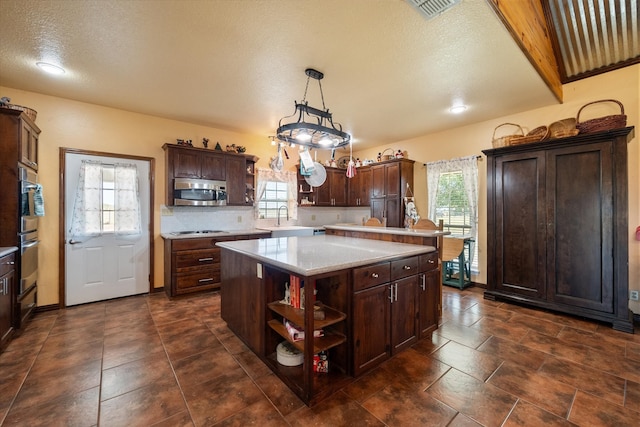 kitchen with a center island, plenty of natural light, and hanging light fixtures