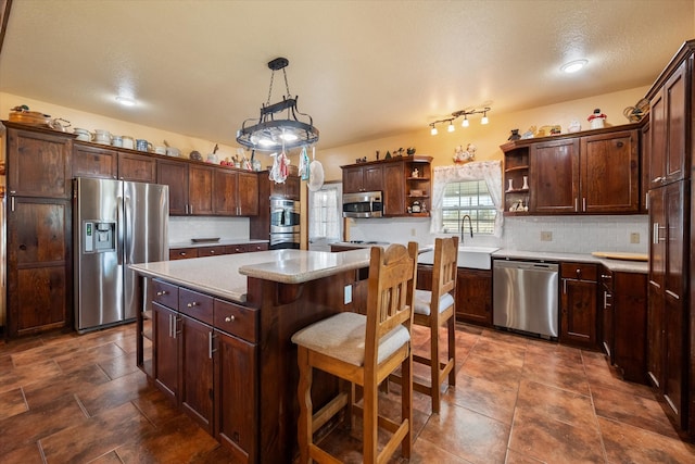 kitchen featuring dark brown cabinets, appliances with stainless steel finishes, a kitchen breakfast bar, and a kitchen island