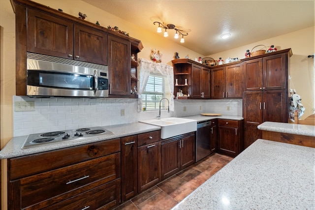 kitchen featuring a textured ceiling, tasteful backsplash, sink, stainless steel appliances, and light stone countertops