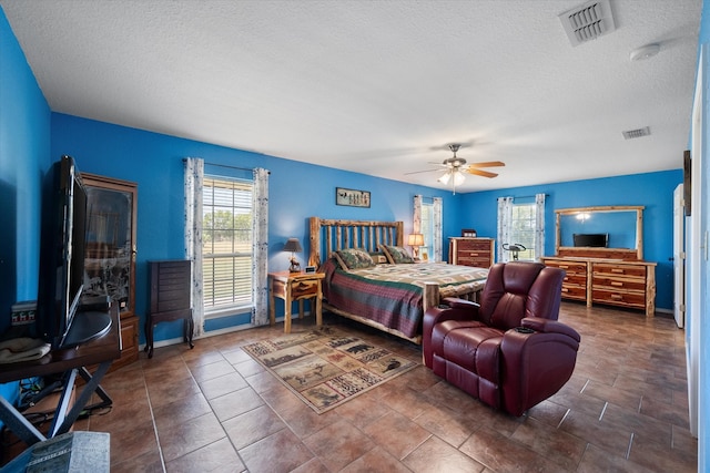 bedroom with ceiling fan and a textured ceiling