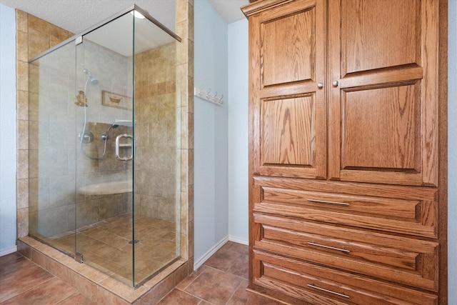 bathroom featuring a textured ceiling, tile patterned floors, and a shower with shower door