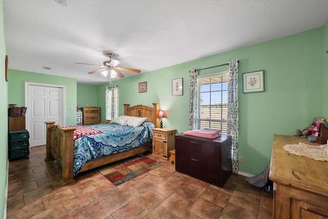 bedroom featuring ceiling fan and a textured ceiling