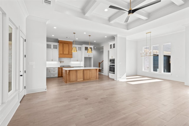 kitchen featuring a spacious island, hanging light fixtures, white cabinets, and coffered ceiling