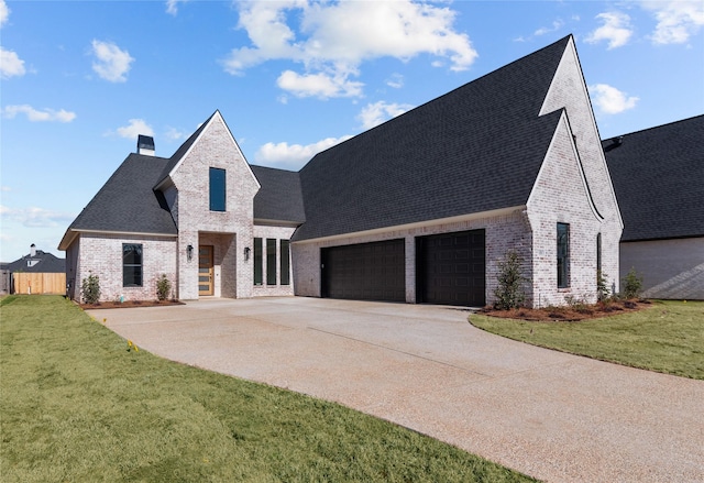 french country inspired facade featuring a garage and a front yard