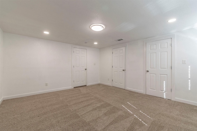 carpeted empty room with baseboards, visible vents, and recessed lighting