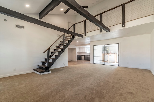 unfurnished living room with light carpet and high vaulted ceiling