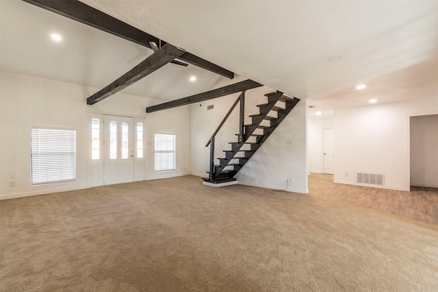 interior space featuring lofted ceiling with beams and light colored carpet