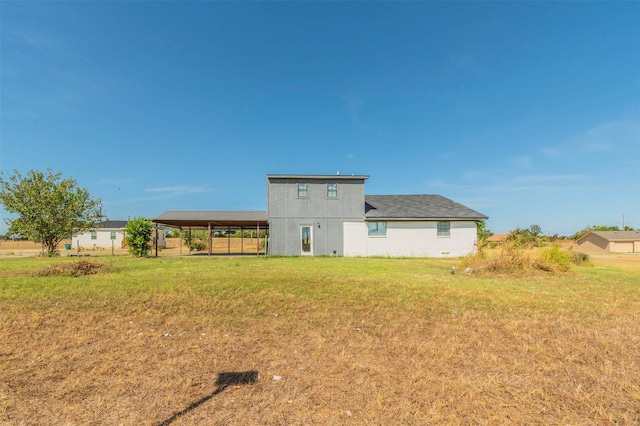 rear view of property featuring a lawn