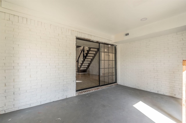 empty room featuring concrete flooring and brick wall