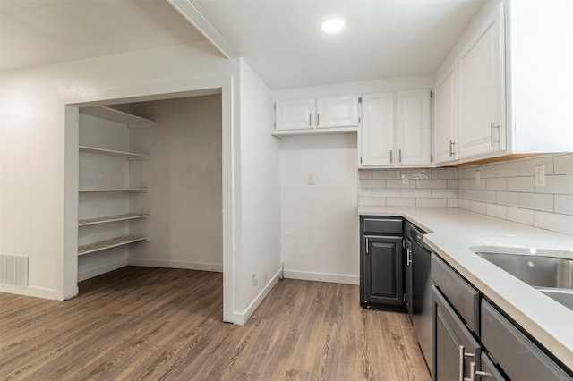 kitchen with white cabinets, backsplash, and wood-type flooring