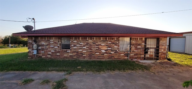 view of home's exterior with a shingled roof and brick siding