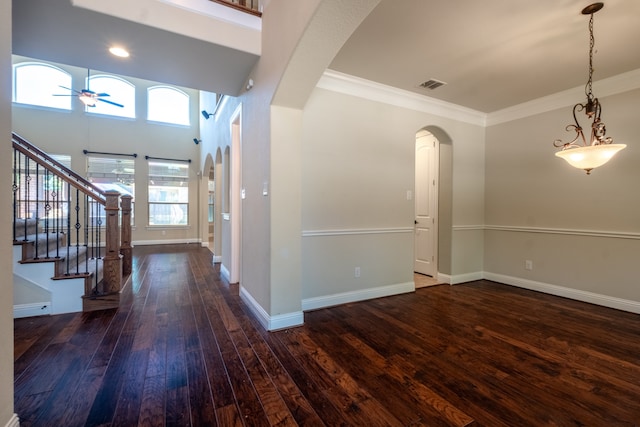 entryway with hardwood / wood-style flooring, ornamental molding, a high ceiling, and ceiling fan