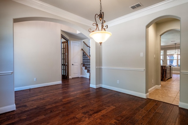 spare room featuring crown molding and dark hardwood / wood-style floors