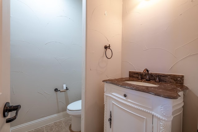 bathroom featuring toilet, vanity, and tile patterned flooring