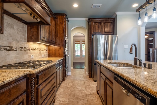 kitchen featuring sink, stainless steel appliances, crown molding, and custom range hood