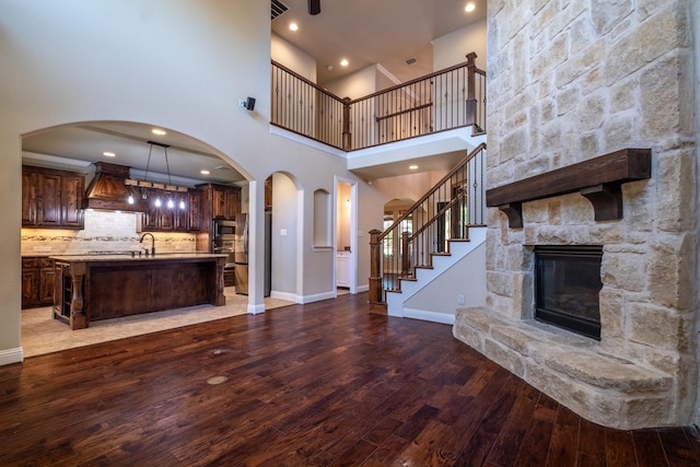 unfurnished living room with a fireplace, sink, and hardwood / wood-style floors