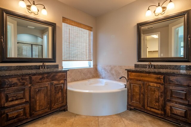 bathroom featuring tile patterned flooring, a tub to relax in, and vanity