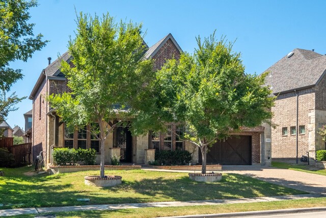 obstructed view of property featuring a front yard and a garage