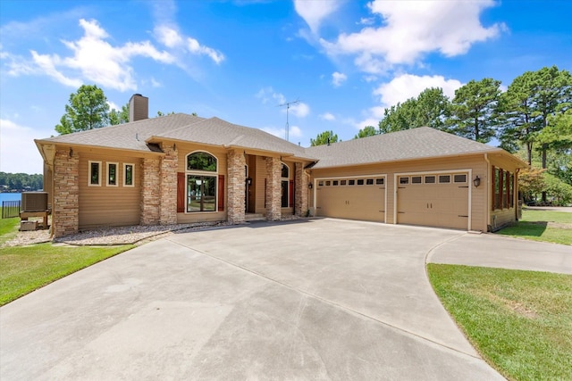 ranch-style house featuring an attached garage, a shingled roof, concrete driveway, stone siding, and a chimney