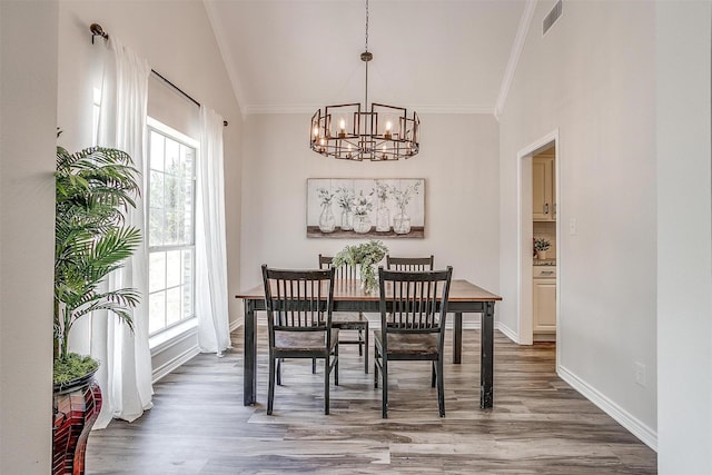 dining space featuring a chandelier, wood-type flooring, and ornamental molding