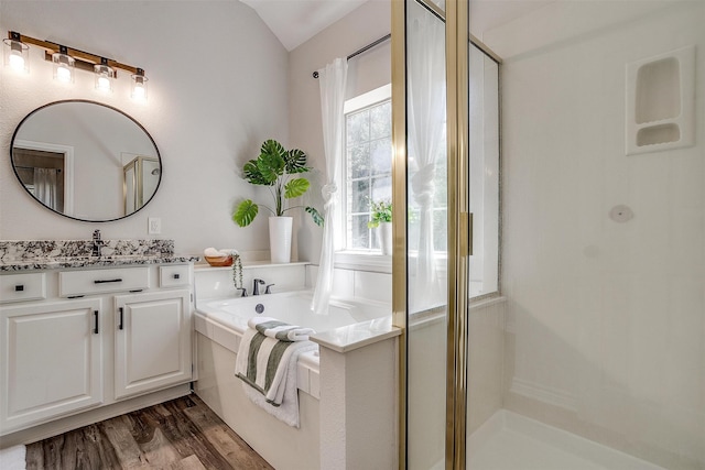 bathroom featuring hardwood / wood-style floors, vanity, lofted ceiling, and walk in shower