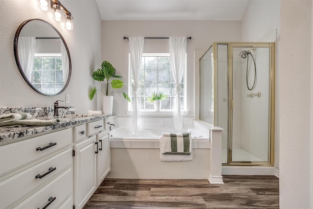 bathroom with hardwood / wood-style floors, vanity, and independent shower and bath