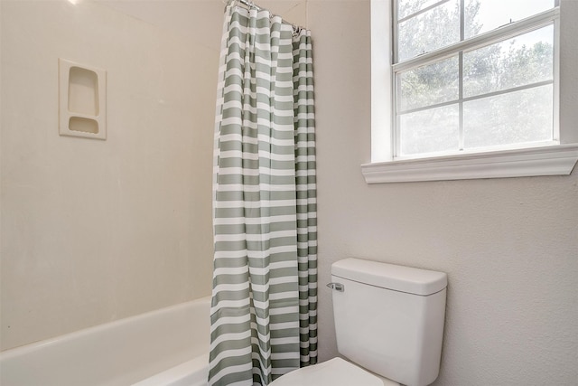 bathroom with shower / bathtub combination with curtain and toilet