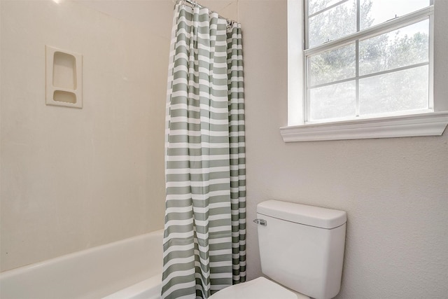 bathroom with shower / tub combo with curtain and toilet