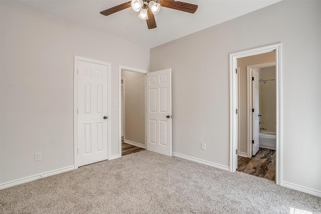 unfurnished bedroom featuring ceiling fan, ensuite bath, and carpet