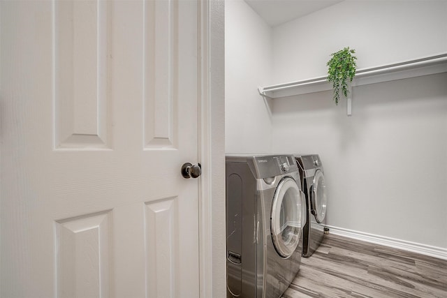 washroom with washer and clothes dryer and wood-type flooring