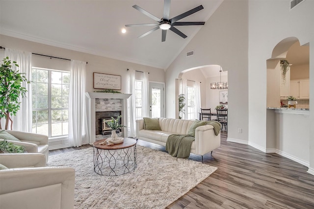 living room with a tile fireplace, high vaulted ceiling, wood-type flooring, and ceiling fan with notable chandelier