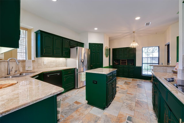 kitchen with appliances with stainless steel finishes, a wealth of natural light, sink, pendant lighting, and a kitchen island