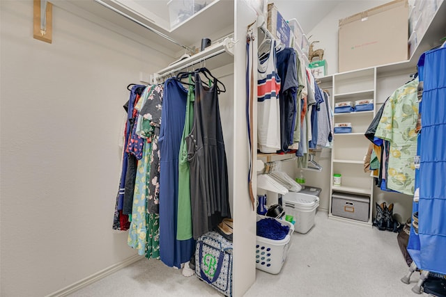 walk in closet with carpet and vaulted ceiling