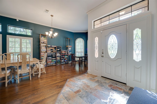 entryway with hardwood / wood-style flooring, a notable chandelier, and ornamental molding