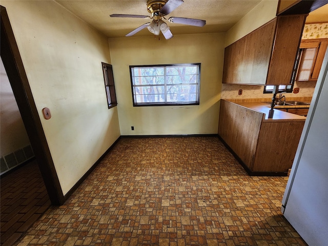 kitchen with ceiling fan, backsplash, and sink