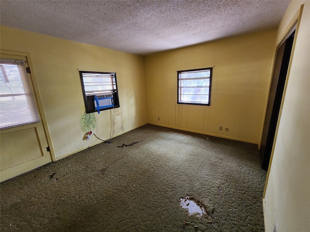 empty room with carpet, a textured ceiling, and cooling unit