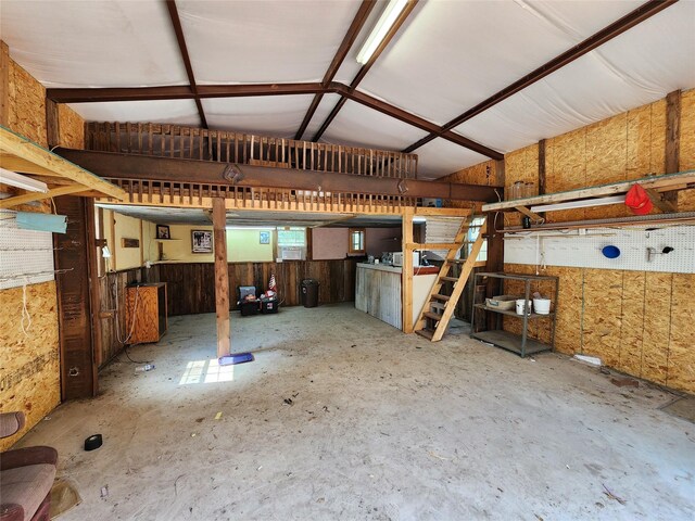 misc room with lofted ceiling and concrete floors