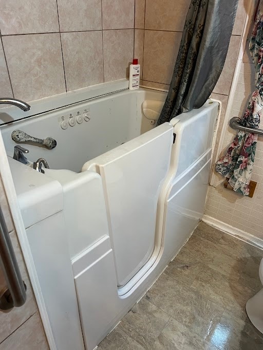 bathroom featuring tile patterned flooring and a bathing tub