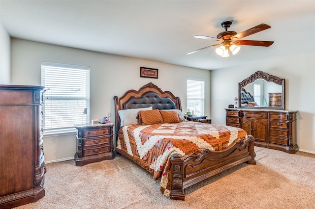 carpeted bedroom with ceiling fan and multiple windows